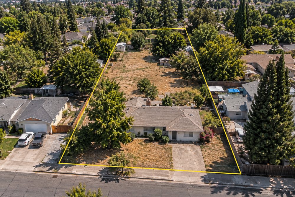 Aerial view of a single-family home on an oversized infill parcel outlined in yellow, representative of redevelopment potential Dottco evaluates
