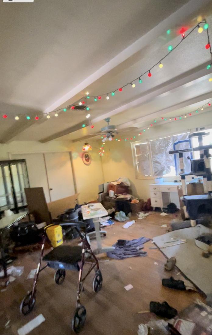 Woodworth living room at acquisition: belongings, medical equipment and debris left throughout